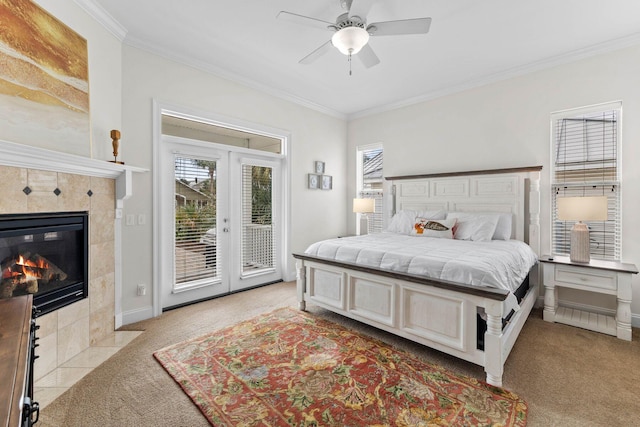 bedroom featuring light carpet, ceiling fan, access to exterior, ornamental molding, and a tiled fireplace