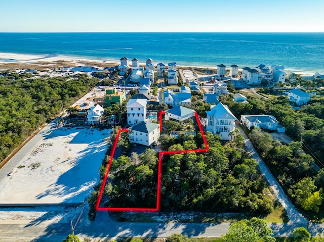 drone / aerial view featuring a water view and a beach view