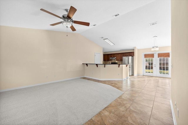 unfurnished living room with french doors, vaulted ceiling, ceiling fan, and light tile patterned flooring