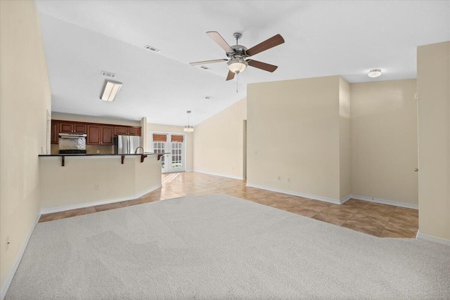 unfurnished living room with ceiling fan, light tile patterned floors, and lofted ceiling