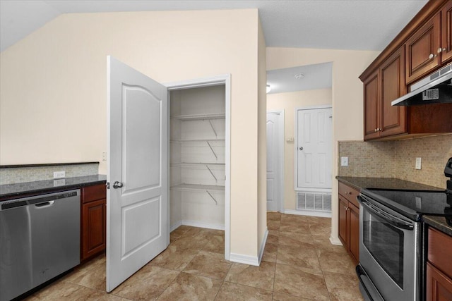 kitchen with dark stone counters, stainless steel appliances, extractor fan, and lofted ceiling