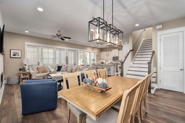 dining area featuring ceiling fan with notable chandelier and dark hardwood / wood-style floors