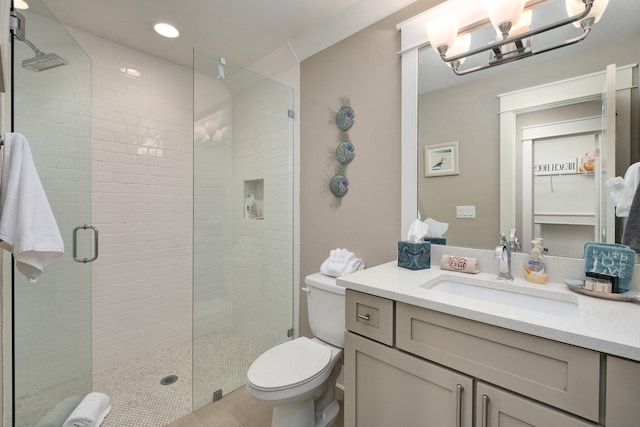 bathroom with an inviting chandelier, walk in shower, tile patterned flooring, toilet, and vanity