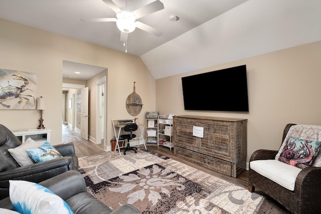 living room with ceiling fan, light hardwood / wood-style flooring, and vaulted ceiling