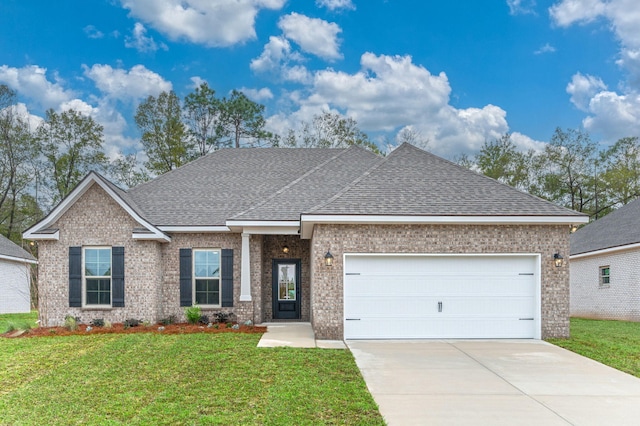 view of front of home with a shingled roof, concrete driveway, an attached garage, a front yard, and brick siding