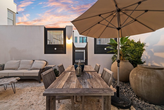 patio terrace at dusk featuring an outdoor living space