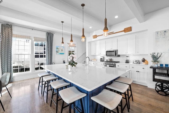 kitchen with hanging light fixtures, appliances with stainless steel finishes, and dark wood-type flooring