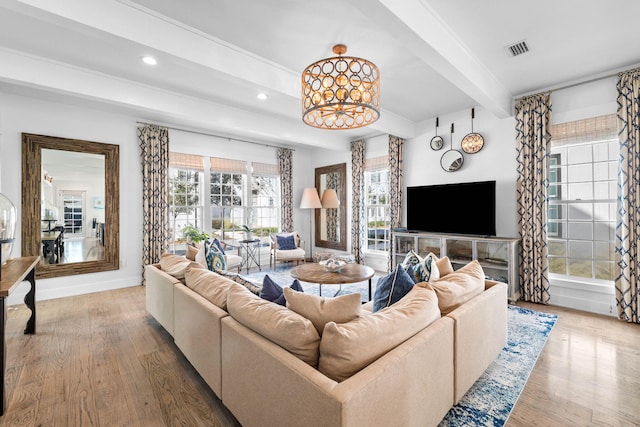 living room with beam ceiling, plenty of natural light, and hardwood / wood-style flooring