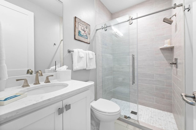 bathroom featuring vanity, a shower with shower door, and toilet