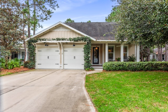 view of front of property featuring covered porch, a front yard, and a garage