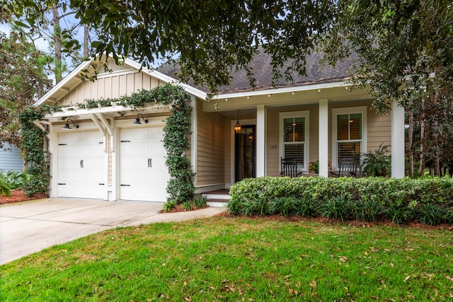 view of front facade featuring a porch, a garage, and a front lawn