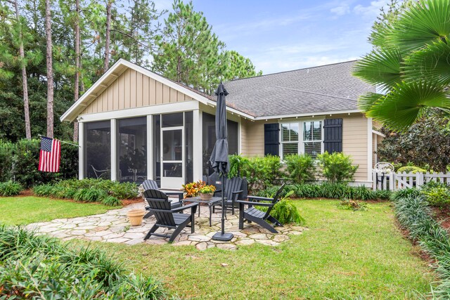 back of house featuring a sunroom, a yard, and a patio