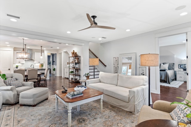 living room with wood-type flooring, ceiling fan, crown molding, and sink