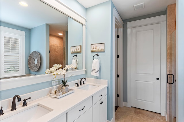 bathroom with tile patterned flooring, vanity, and a shower with door