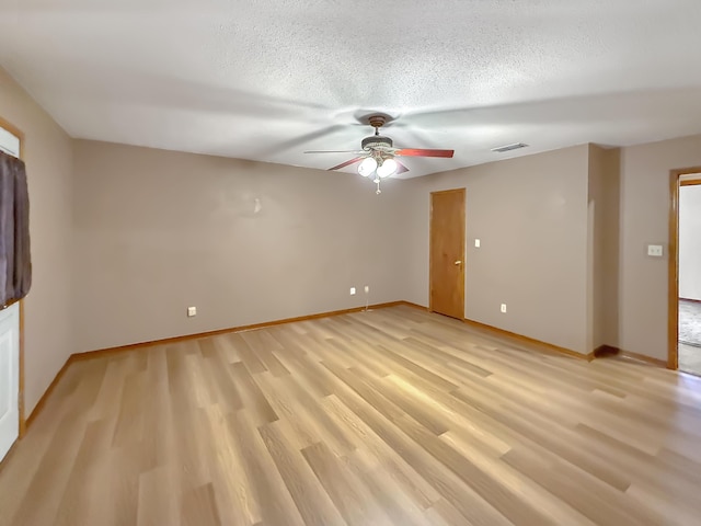 empty room featuring ceiling fan, light hardwood / wood-style floors, and a textured ceiling