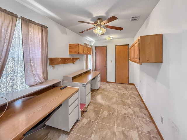 kitchen with ceiling fan, a textured ceiling, and light tile patterned flooring