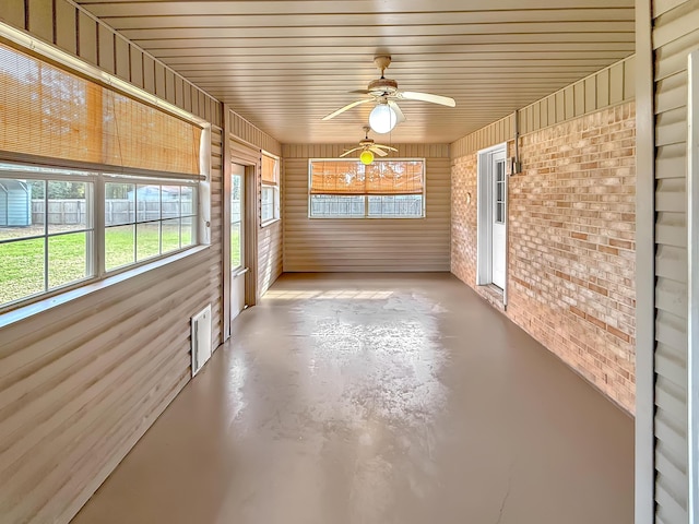 unfurnished sunroom featuring ceiling fan