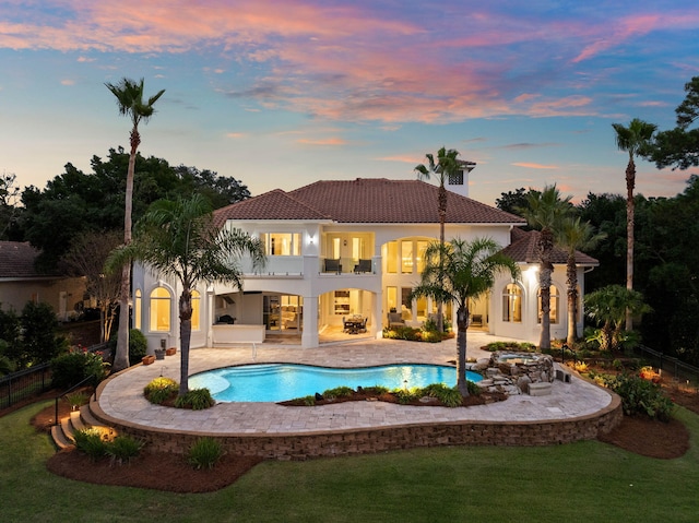 pool at dusk with a patio area