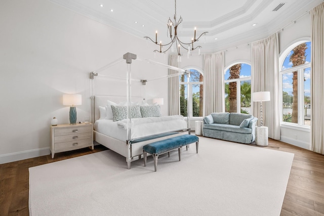 bedroom with crown molding, a towering ceiling, wood-type flooring, and a notable chandelier