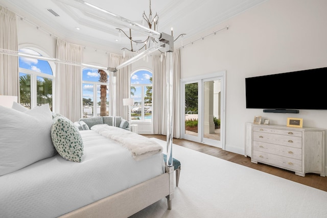 bedroom featuring dark hardwood / wood-style floors, an inviting chandelier, access to exterior, and multiple windows