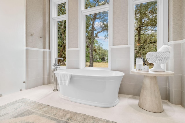 bathroom with plenty of natural light, tile walls, and a washtub