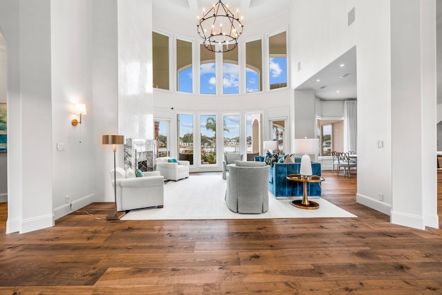 unfurnished living room with a chandelier, dark hardwood / wood-style floors, and a high ceiling