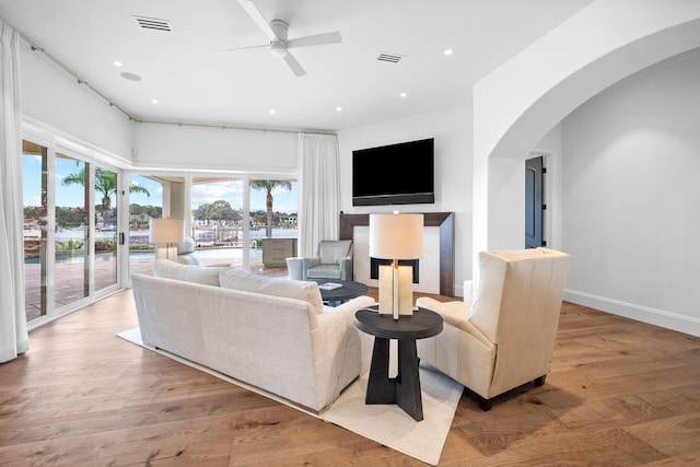 living room featuring a wealth of natural light, ceiling fan, and hardwood / wood-style flooring