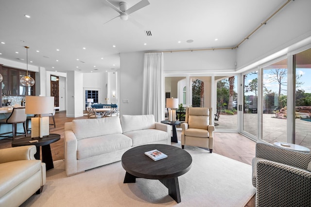 living room with ceiling fan and light hardwood / wood-style flooring