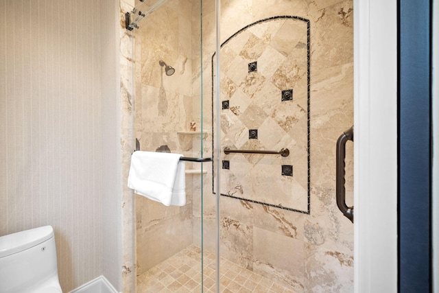 bathroom with a shower with door and toilet