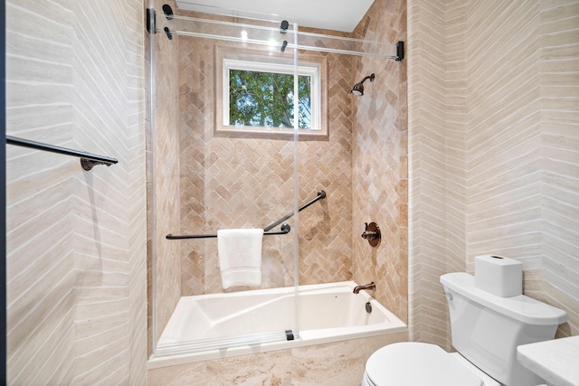 bathroom featuring tiled shower / bath combo and toilet