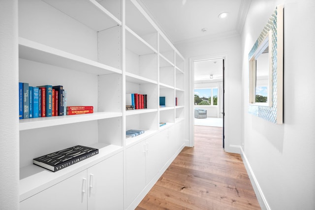 corridor with crown molding and light wood-type flooring