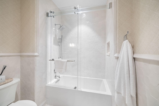 bathroom featuring combined bath / shower with glass door and toilet