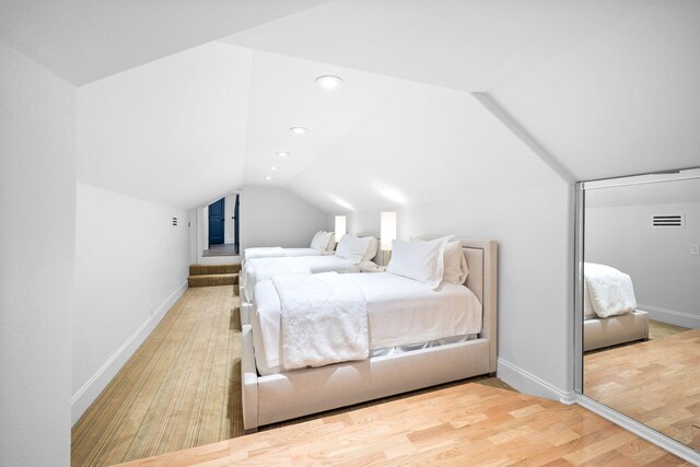 bedroom featuring wood-type flooring and vaulted ceiling