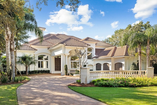 mediterranean / spanish home featuring a front yard