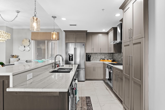 kitchen with hanging light fixtures, wall chimney exhaust hood, appliances with stainless steel finishes, a large island, and a chandelier