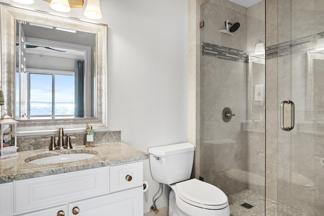 bathroom featuring vanity, toilet, and a shower with door