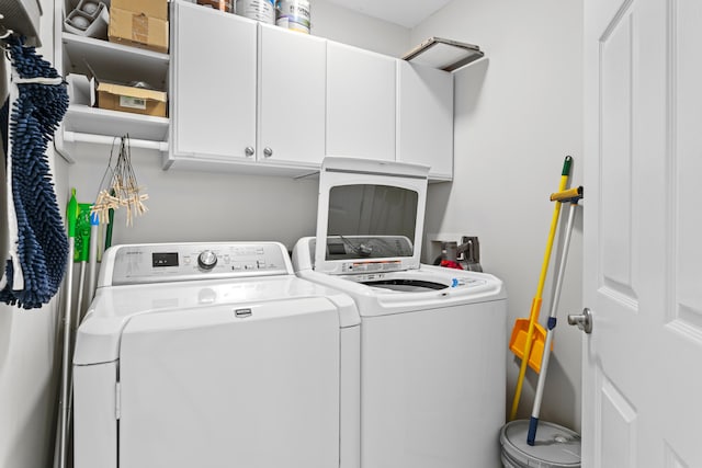 washroom featuring cabinets and separate washer and dryer