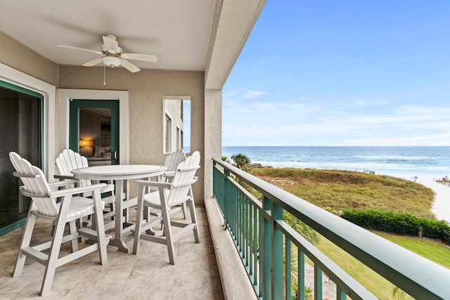 balcony with ceiling fan and a water view