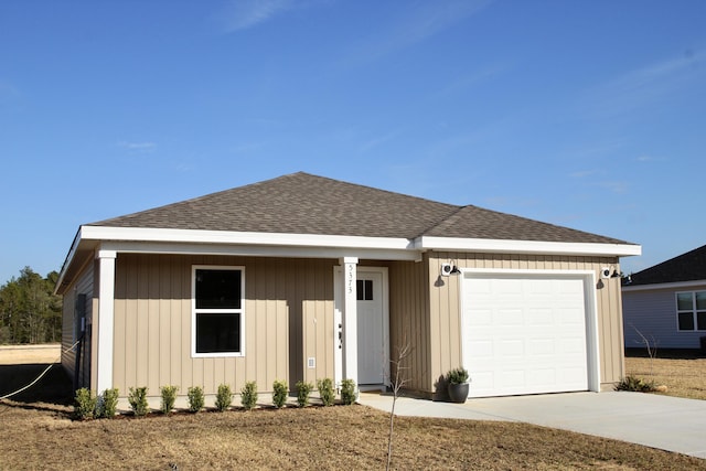 ranch-style home featuring an attached garage, a shingled roof, and driveway