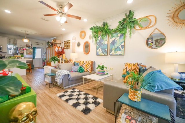 living room featuring ceiling fan and light hardwood / wood-style floors