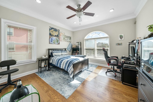 bedroom with ceiling fan, light wood-type flooring, crown molding, and multiple windows