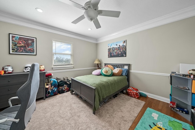 bedroom with hardwood / wood-style floors, ceiling fan, and ornamental molding