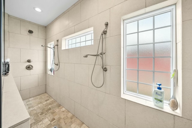 bathroom featuring plenty of natural light and tiled shower