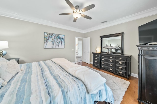 bedroom with ceiling fan, wood-type flooring, and ornamental molding