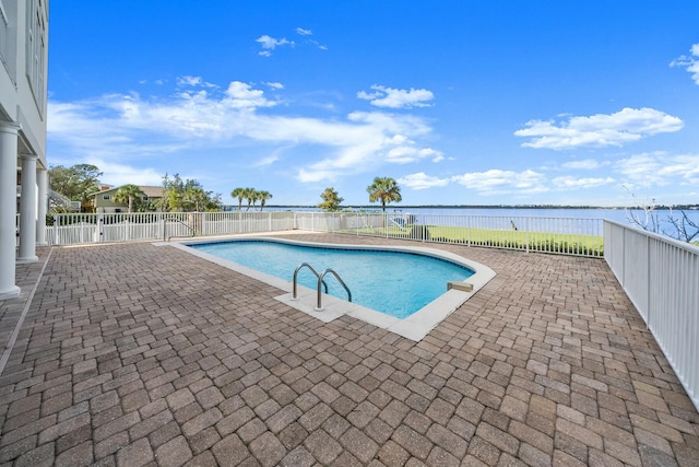 view of pool featuring a water view and a patio area