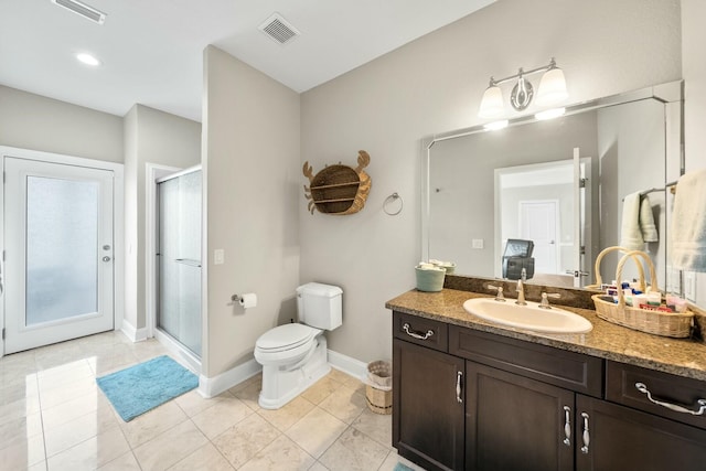 bathroom with tile patterned flooring, vanity, toilet, and a shower with door