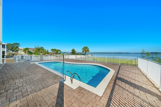 view of swimming pool with a patio and a water view