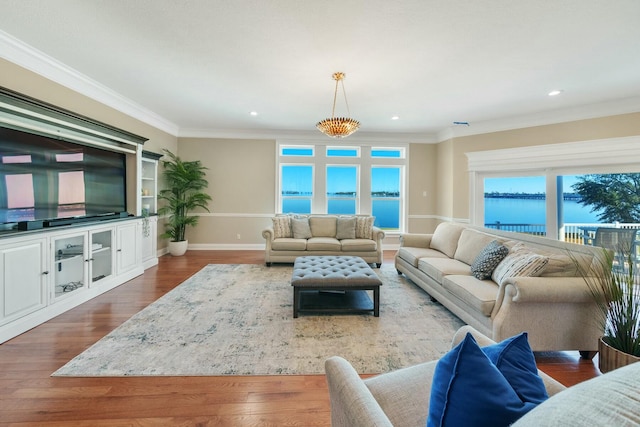 living room featuring dark hardwood / wood-style floors, a water view, and ornamental molding