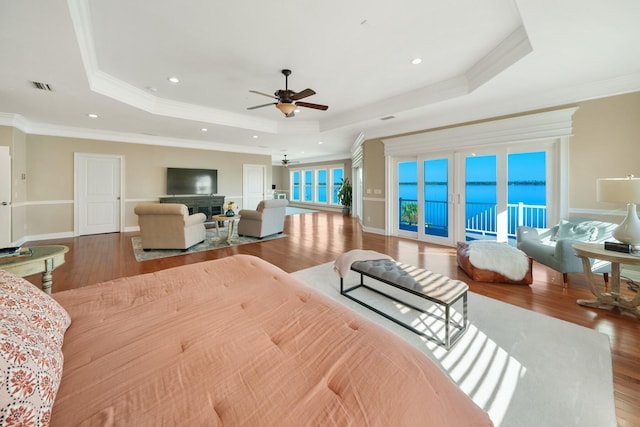 bedroom featuring hardwood / wood-style flooring, a raised ceiling, and french doors