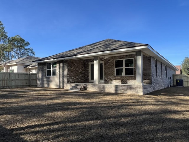 view of front of property with a front lawn and central AC